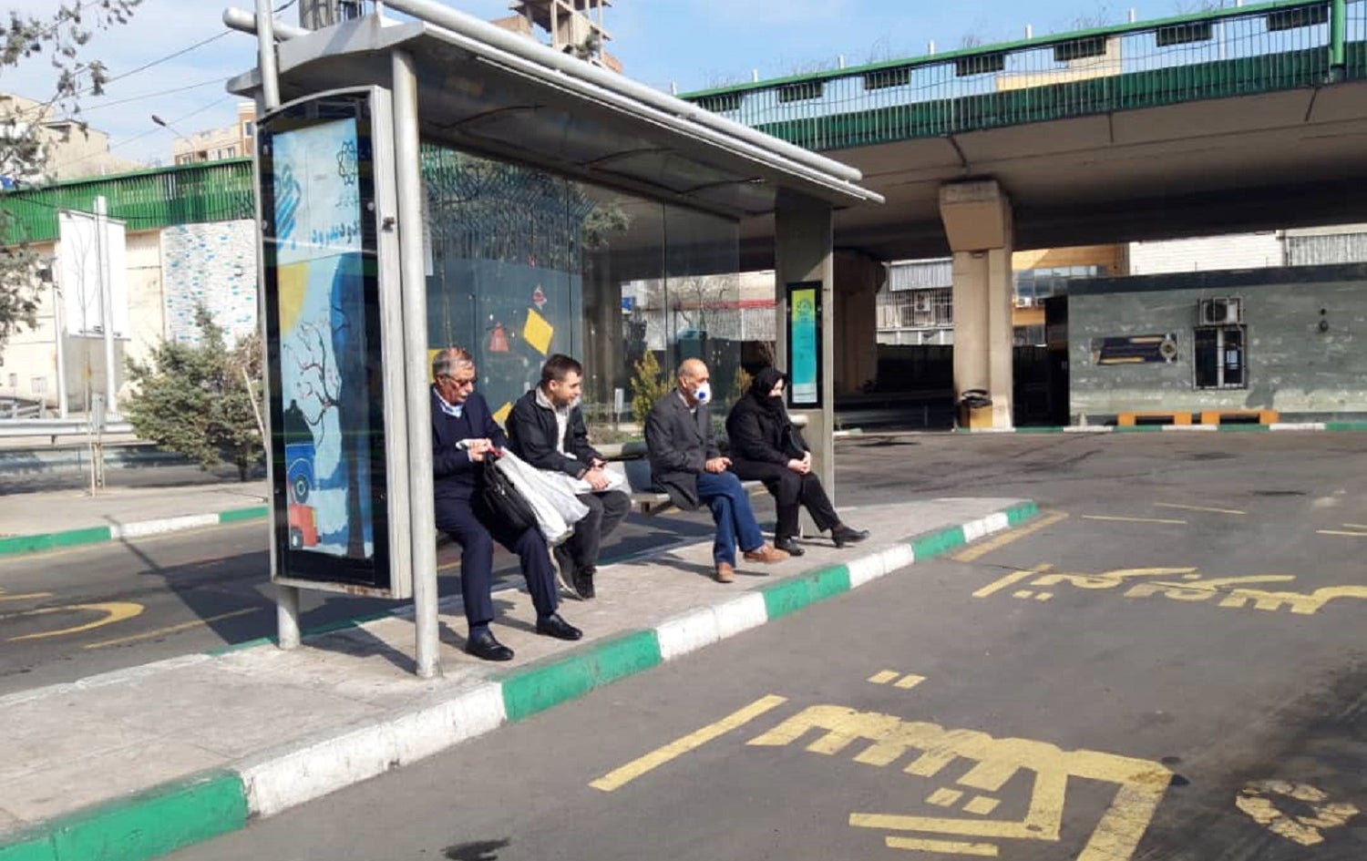 People wait for a bus on Tehran’s Valiasr Street on March 19, 2020. Photo: Aso Mohammadi